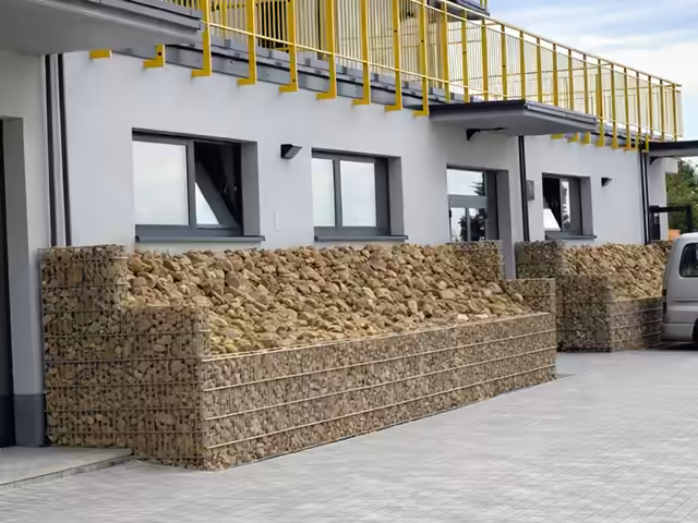 Gabiony aranżacje – mur gabionowy przy nowoczesnym budynku